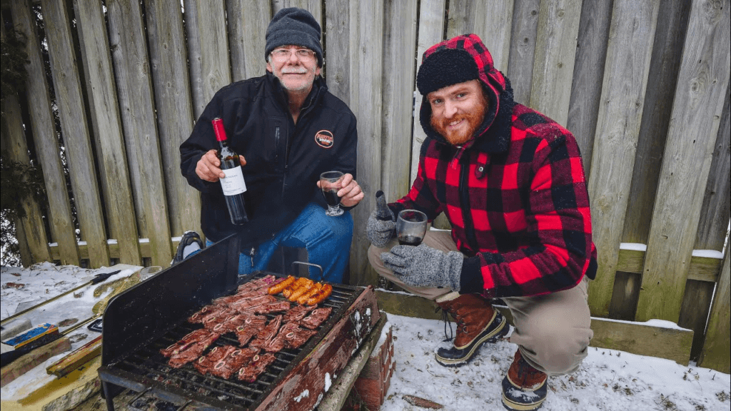 Duas pessoas fazendo churrasco ao ar livre no inverno