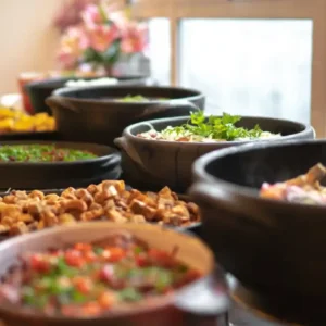 Mesa de acompanhamentos da feijoada - panelas de barro
