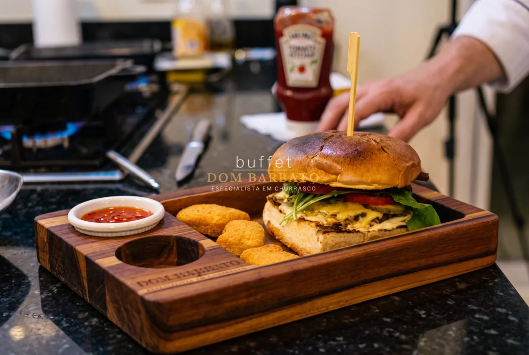 Hambúrguer com queijo, tomate e rúcula em tábua de madeira, ao lado de nuggets e molho, com ketchup ao fundo.