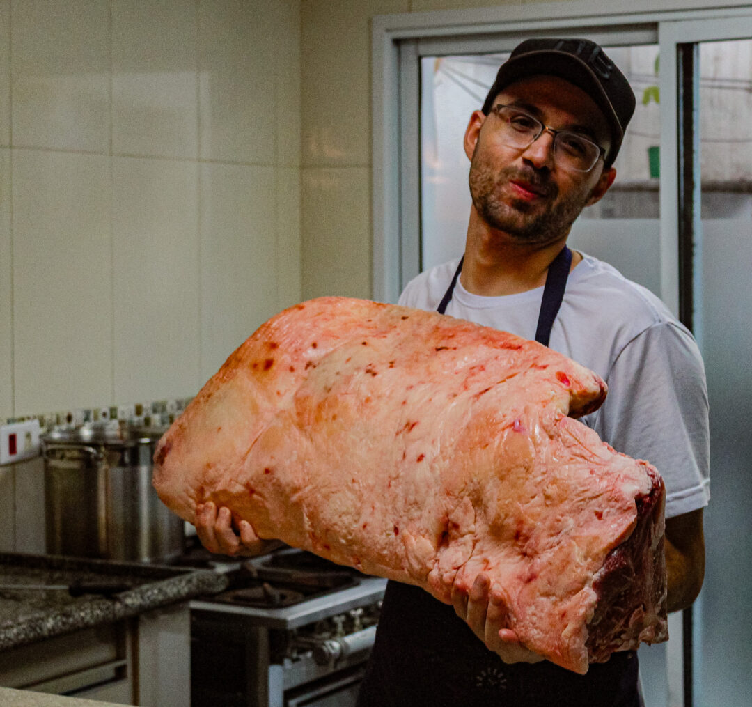 Chef Dom do Buffet Dom Barbato segura um grande corte de carne bovina crua em cozinha