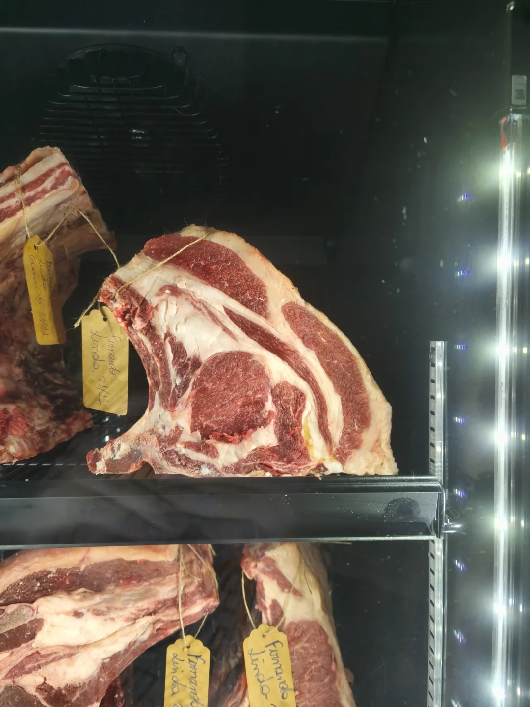 Peças de lombo bovino com osso e capa de gordura em câmara refrigerada com etiquetas